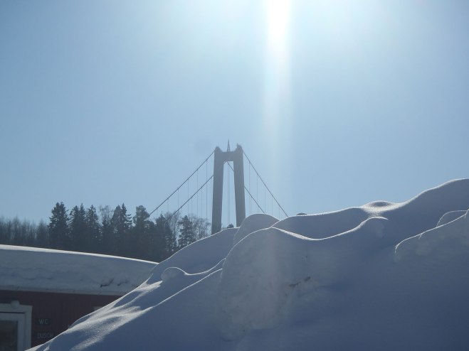 Höga kustenbrons pylon över snöhög.