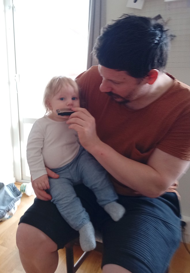 Mattias lär Nils spela munspel.